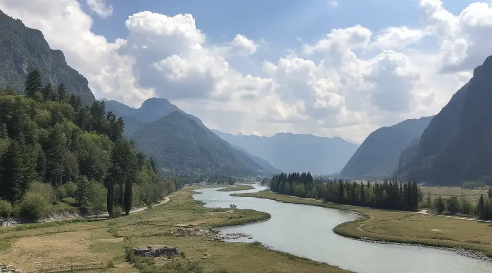 雲のかかる山あいを、川がゆるやかに流れる風景（イメージ写真）