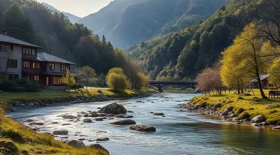 山あいの川沿いに、木造の建物と紅葉した木々が見える風景（イメージ写真）